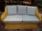 (R3) WICKER LOVESEAT WITH BLUE STRIPE UPHOLSTERED CUSHIONS. IS 1 OF A PAIR. MEASURES 70 IN X 38 IN X