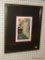 (R3) FRAMED PAINTING OF A WOMAN SITTING DOWN WITH A VASE OF FLOWERS. IS SIGNED 