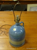 (R2) POTTERY JUG STYLE LAMP WITH HARP. MEASURES 18.5 IN TALL. ITEM IS SOLD AS IS WHERE IS WITH NO
