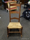 (R2) OAK RUSH BOTTOM ROCKING CHAIR WITH LADDER BACK. MEASURES 20 IN X 32 IN X 41 IN. ITEM IS SOLD AS