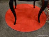 (R2) ROUND RED AREA RUG. MEASURES APPROXIMATELY 4 FT IN DIA. ITEM IS SOLD AS IS WHERE IS WITH NO