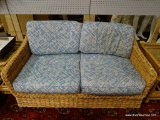 (R3) WICKER LOVESEAT WITH BLUE FLORAL UPHOLSTERED CUSHIONS. MEASURES 53 IN X 29 IN X 30 IN. ITEM IS