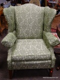 (R3) SIGMONS GREEN UPHOLSTERED WING BACK CHAIR WITH MAHOGANY LEGS. IS 1 OF A PAIR. MEASURES 34 IN X