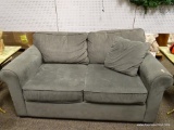 (R3) GRAY UPHOLSTERED LOVESEAT WITH AN ACCENT PILLOW. MEASURES 62 IN X 38 IN X 35 IN. ITEM IS SOLD