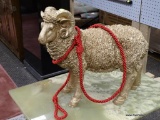 (R3) GOLD PAINTED RAM WITH RED ROPE ACCENT. MEASURES 19 IN X 18 IN. ITEM IS SOLD AS IS WHERE IS WITH