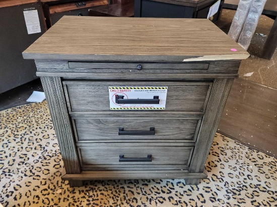 A AMERICA 3 DRAWER NIGHTSTAND GRAYSTONE; SOME DAMAGE ON FRONT; HAS POWER CORD; RETAILS FOR $499.99;