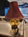CUTE MODERN GLASS BOTTOM WITH MAROON SHADE LAMP. HAS A CLICKER NEAR THE PLUG TO TURN ON AND OFF. IS