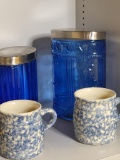 BLUE CANISTERS WITH LIDS AND BLUE AND WHITE MUG SET. IS SOLD AS IS WHERE IS WITH NO GUARANTEES OR