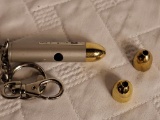 (SC) LASER POINTER KEY CHAIN IN THE SHAPE OF A BULLET WITH GOLD ATTACHMENTS. IS SOLD AS IS WHERE IS