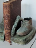 COPPER BABY BOOTIES BOOKENDS ON A STAND WITH A HISTORY OF VIRGINIA BOOK BY MARY MAGILL. COPYRIGHT