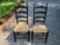 (SHED1) PAIR OF BLACK WOODEN RUSH BOTTOM LADDER BACK CHAIRS.