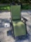 (SHED 2) GREEN AND BLACK FOLDING LOUNGE CHAIR WITH SIDE TABLE AND CUPHOLDER, APPEARS LIKE A DOG WAS