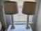 (BED3) PAIR OF WHITE WOODEN COLUMN STYLE TABLE LAMPS, BOTH WITH SHADES. THEY MEASURE APPROX. 27-1/2