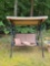 (BACKYARD) BLACK METAL OUTDOOR GLIDER LOVESEAT WITH TAN SUN SHADE AND TWO ORANGE AND WHITE THROW