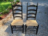 (SHED1) PAIR OF BLACK WOODEN RUSH BOTTOM LADDER BACK CHAIRS.