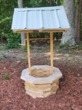 (FRONT) DECORATIVE WOODEN WELL WITH WHITE METAL ROOF. WOOD HAS NOT BEEN STAINED OR SEALED YET (LOOKS