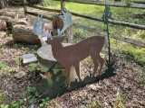 (DRIVEWAY BY ENTRNACE) PAINTED METAL CUT OUT OF A BUCK AROUND PLANTS WITH A WOODPECKER.