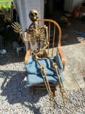 (SHED 2) GOLD PLASTIC SKELETON WITH LED EYES, LOCKED IN THE SITTING POSITION, PLEASE SEE THE