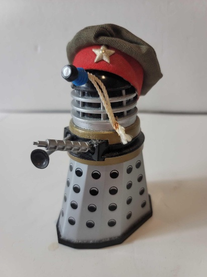 BLACK AND SILVER WIND UP DOCTOR WHO DALEK TOY WITH MILITARY HAT. MEASURES APPROX 5" TALL