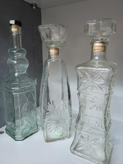 3 GLASS WINE DECANTERS. VARIOUS SIZES AND DESIGNS. IS SOLD AS IS WHERE IS WITH NO GUARANTEES OR