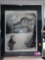 FRAMED PRINT TITLED LIGHTS BACK ON, IT HAS A MAN WEARING A COAT THAT SAYS FORGOTTEN AMERICAN