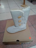 PAIR OF UGG WINTER BOOTS WITH THREE BUTTON SIDE, FUR IN THE INSIDE AND COLOR IS BEIGE.
