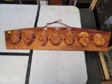 7 FACE HAND CARVED ON PINE PLANK, WITH CHINESE SCRIPT 35 IN X 8 IN.