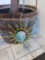 METAL AND MARBLE SUN OUTDOOR DECORATION. BLUE AND GREEN MARBLE SPHERE SUSPENDED ON YELLOW METAL SUN.