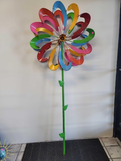 BENCHMADE METAL FLOWER WINDMILL YARD DECORATION. MULTI-COLORED "PETALS" MAKE UP THE 2 WHEELS THAT