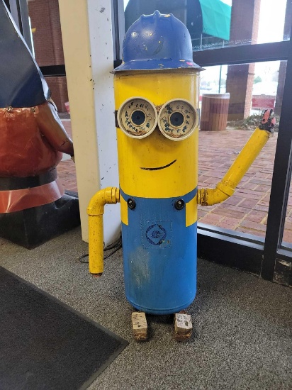 BENCHMADE MINIONS YARD ORNAMENT MADE FROM AN OLD TANK. PAINTED YELLOW WITH BLUE OVERALLS. HAS A BLUE