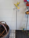 METAL YARD ORNAMENT OF A YELLOW HUMMINGBIRD. SITS ON METAL POLE WITH A HOOK ON THE END TO HANG