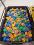 BLACK AND YELLOW TOTE LOT OF ASSORTED GUMBALL MACHINE CAPSULES. MOST APPEAR TO BE BOK CHOY BOYS