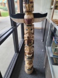 CARVED WOODEN TOTEM POLE. PAINTED NAVY BLUE, BURGUNDY AND YELLOW. MEASURES APPROX. 6