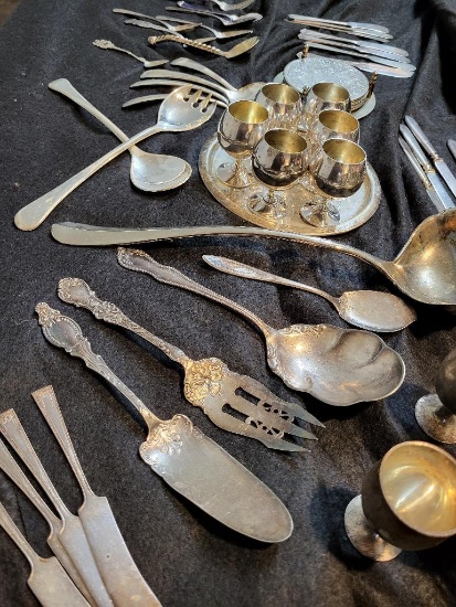 OVER 50 PIECE SILVERPLATE LOT. INCLUDES LADLES, SPOONS, FORKS, COASTERS AND MUCH MORE. IS SOLD AS IS