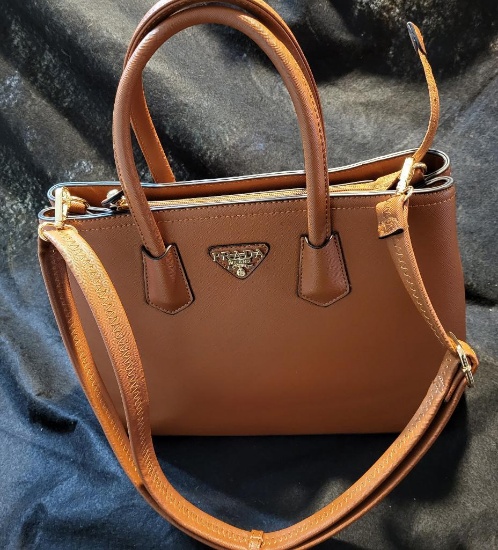 BROWN SHOULDER BAG. APPEARS TO BE BRAND NEW. TONS OF COMPARTMENTS FOR ALL YOUR NEEDS. IS SOLD AS IS