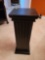 (HBATH) DECORATIVE BLACK PLASTIC COLUMN DESIGNED PLANT STAND. IT MEASURES APPROX. 9