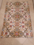 (LAUNDRY) CHATHAM MACHINE MADE RUG. CREAM COLORED WITH BLUE, RED AND BROWN ACCENTS. MEASURES APPROX