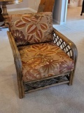 (LR) VINTAGE RATTAN ARM CHAIR WITH TROPICAL LEAF UPHOLSTERY & WOVEN RATTAN SIDES & BACK. IT MEASURES