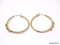 PAIR OF 14K YELLOW GOLD PIERCED HOOP EARRINGS WITH A ROW OF 3 GOLD FLOWER DETAILING ON EACH. MARKED