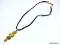 LIA SOPHIA GOLD TONE PENDANT WITH 4 VARIOUS CUT YELLOWISH/GREEN GEMSTONES, DISPLAYED ON A CLOTH