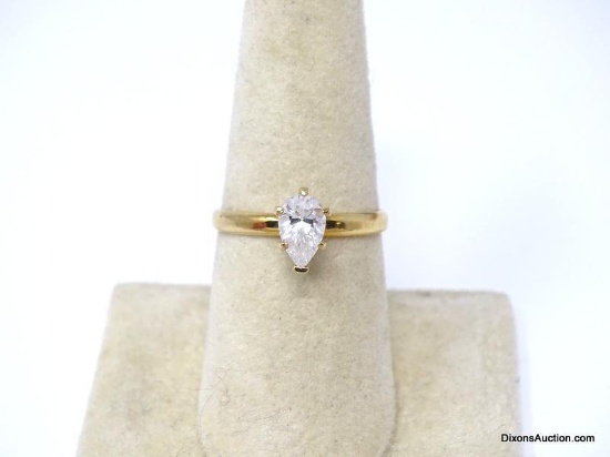 GOLD TONE ENGAGEMENT RING WITH APPROX. 1 CT. PRONG SET PEAR CUT CZ CENTER STONE. THE RING SIZE IS