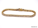 NICE .925 STERLING SILVER GOLD VERMEIL TENNIS BRACELET LINED WITH SQUARE CUT CLEAR CZ GEMSTONES.