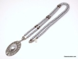 1928 BRAND SILVER TONE OVAL FILIGREE PENDANT WITH A LARGE OVAL SILVER TONE FAUX PEARL, ACCENTED WITH