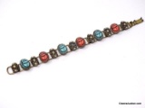 VINTAGE BRASS RED CORAL & TURQUOISE COLORED SCARAB BRACELET WITH FLORAL/SEED PEARL DETAILING. IT