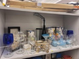 SHELF LOT OF ASSORTED DECOR ITEMS TO INCLUDE: CLEAR STEMWARE, 4 SMALL SUNBURST STYLE WALL MIRRORS,