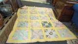 HANDMADE SQUARE PATTERN QUILT WITH A FLORAL DESIGN ON THE BACK MEASURES APPROXIMATELY 74 IN X 90 IN