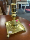 FOOTED BASE BRASS CANDLESTICK HOLDER; VERY HEAVY; STAMPED; MEASURES 5.5 X 5.5 X 7 (INCHES)