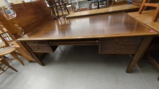 KNEE HOLE WOODEN FOUR DRAWER DESK WITH A SLIDE OUT KEYBOARD DRAWER MEASURES APPROXIMATELY 71 IN X 35