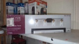 HOME DECORATORS COLLECTION GODDARD 4 LIGHT VANITY FIXTURE, IN THE ORIGINAL BOX SEALED.