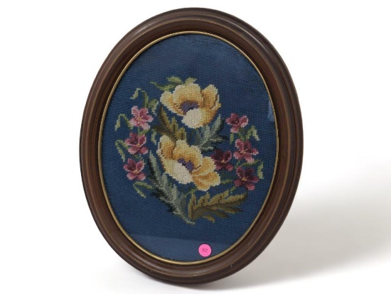 (FOYER) VINTAGE HAND STITCHED NEEDLEPOINT ART DEPICTING A FLORAL SCENE. DISPLAYED IN AN OVAL BROWN